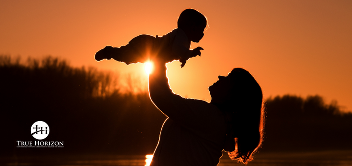 Mom holding up baby